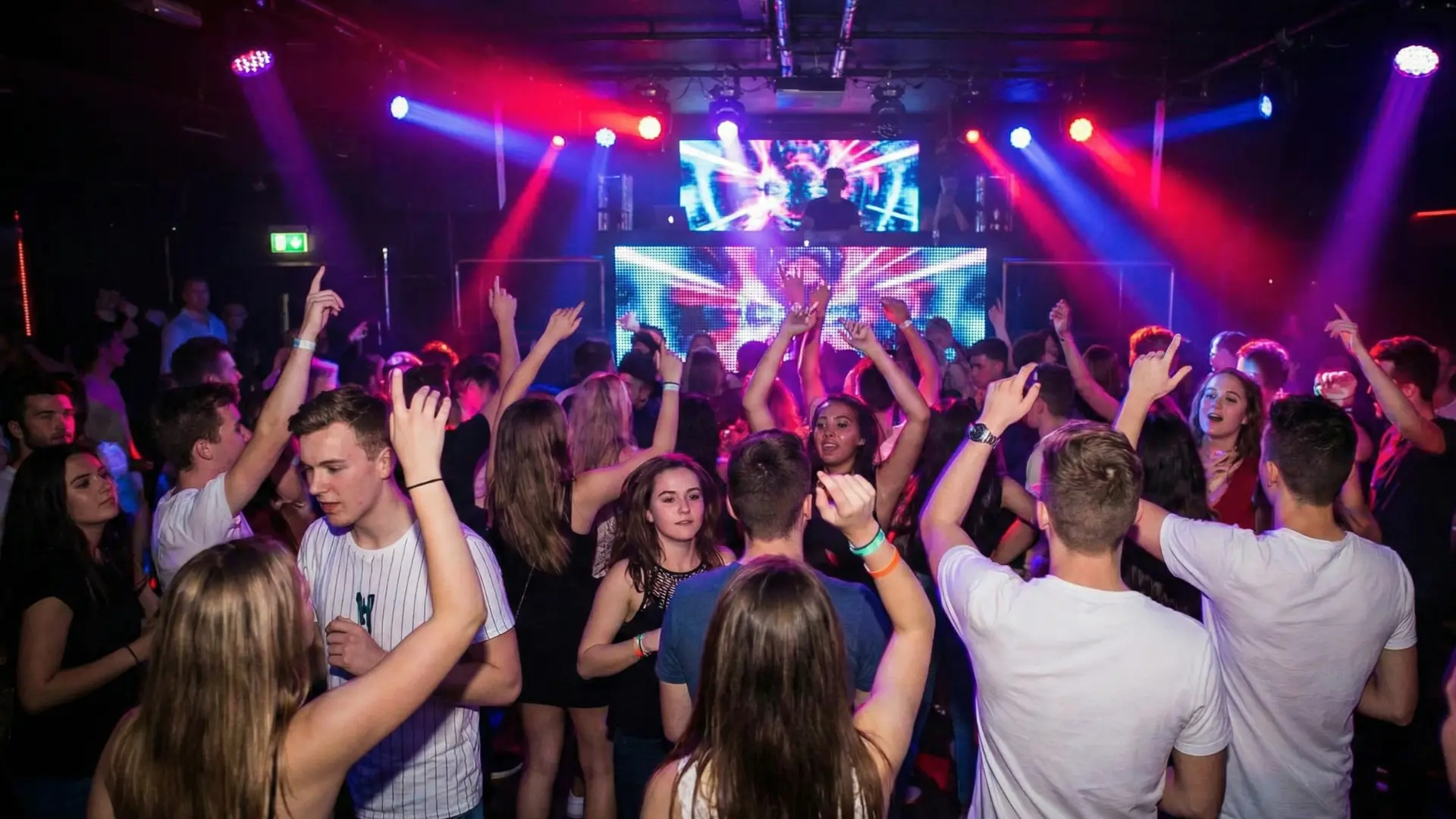 DJ controller and production gear in a neon lit studio.
